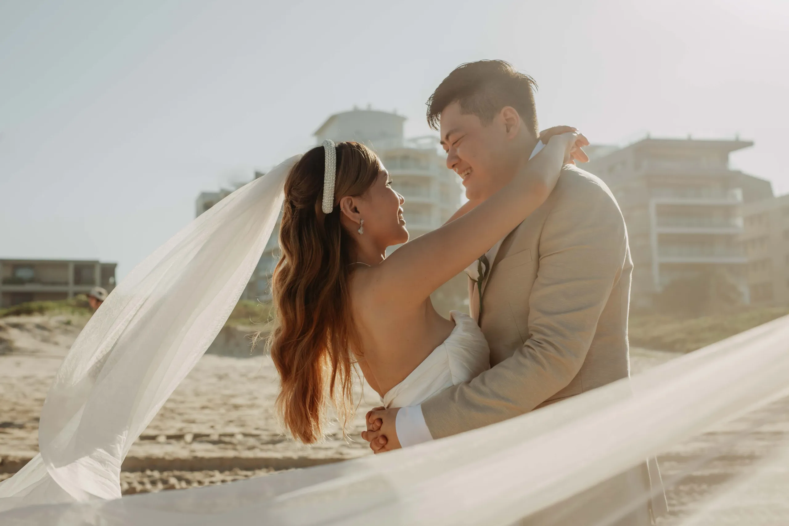 A bride and groom embracing in the sunshine