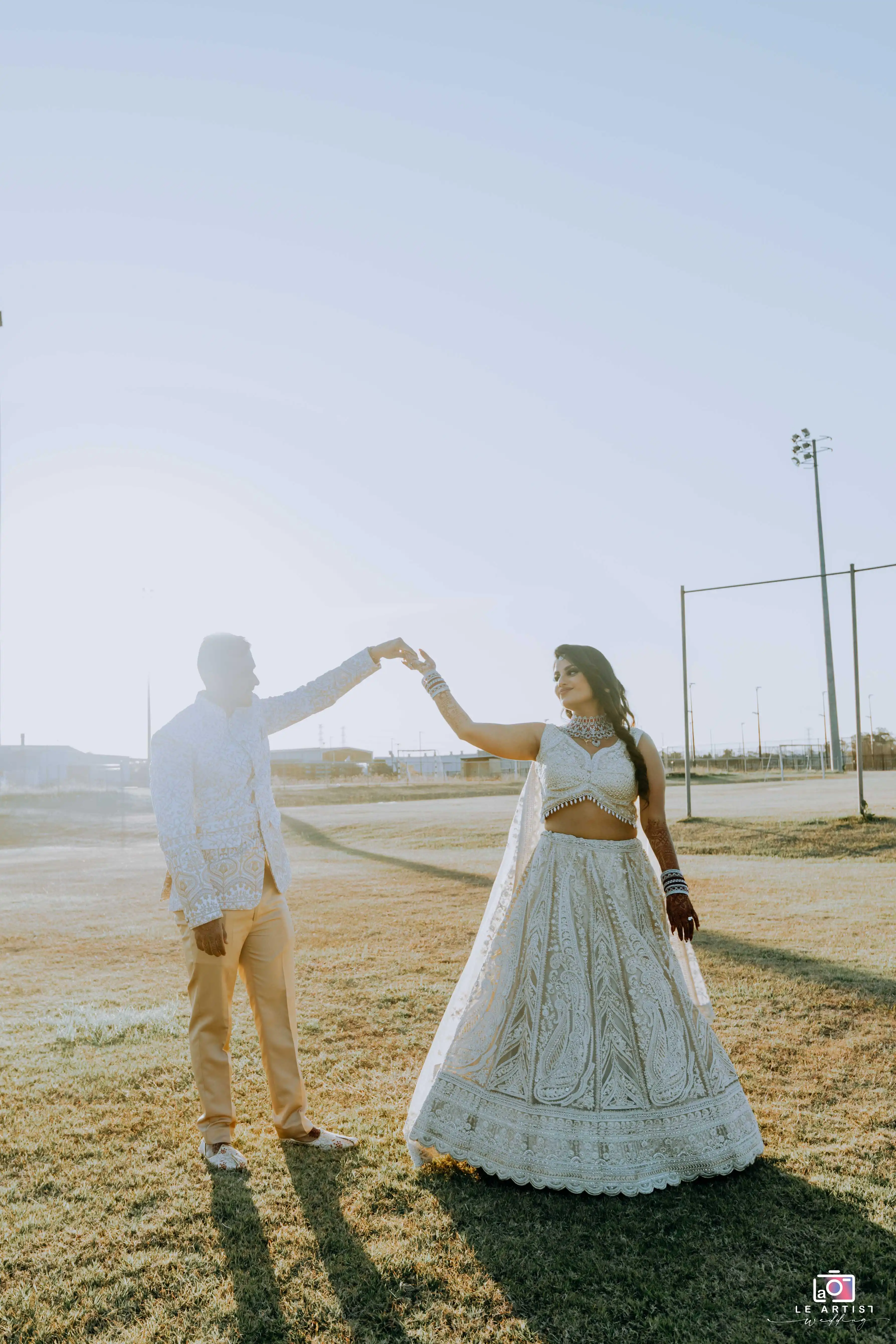 The couple shares a romantic dance moment during their bridal photoshoot in the golden light. Le Artist Wedding