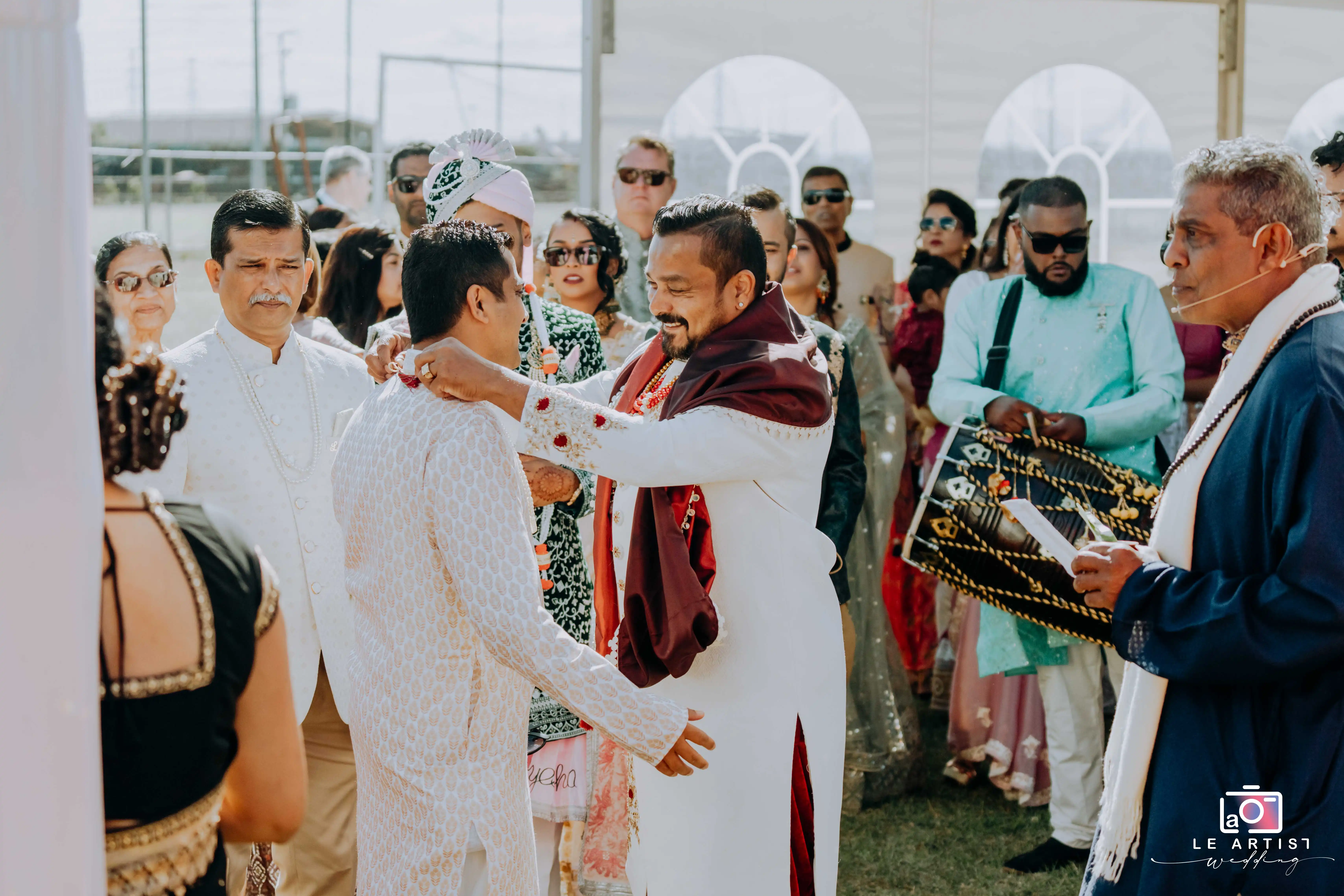A vibrant ceremony moment as a joyful exchange takes place among the guests, demonstrating cultural traditions and unity. Le Artist Wedding