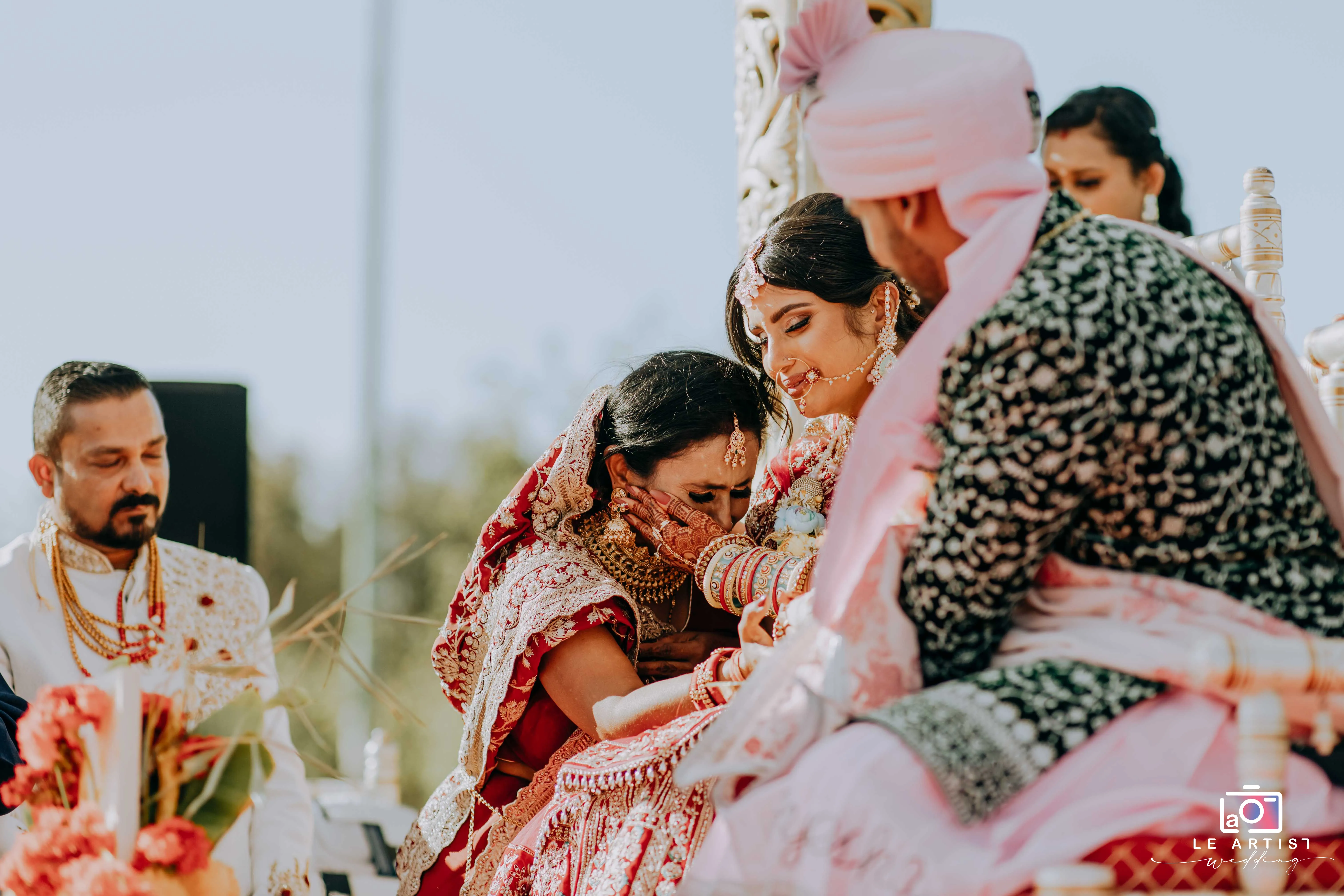 A heartfelt moment during the ceremony as the bride shares an emotional embrace, surrounded by family and tradition. Le Artist Wedding