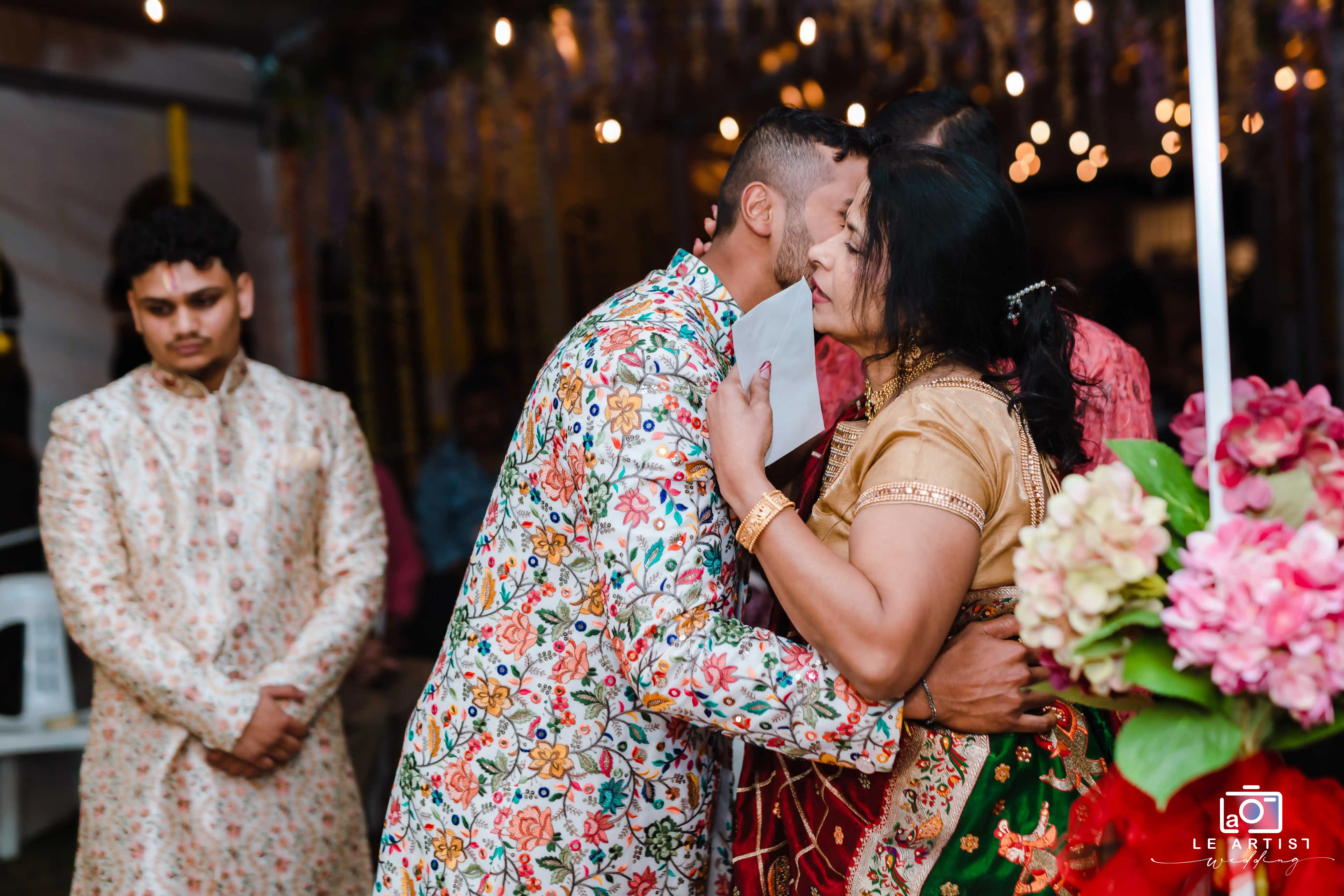 An emotional embrace during the reception as guests share heartfelt moments. Le Artist Wedding