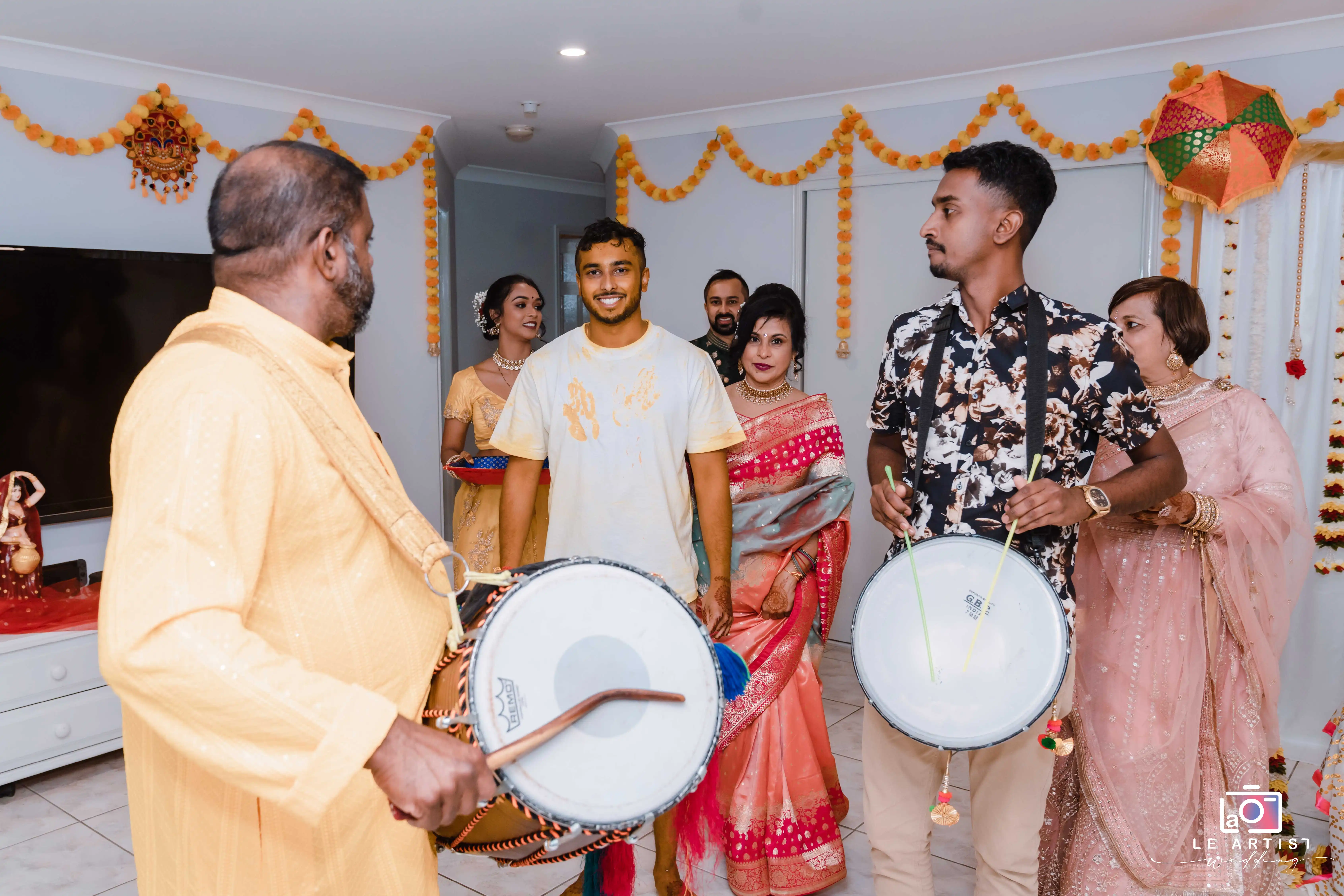 Guests enjoy lively music and dancing with traditional drums during the wedding reception, enhancing the celebratory atmosphere. Le Artist Wedding