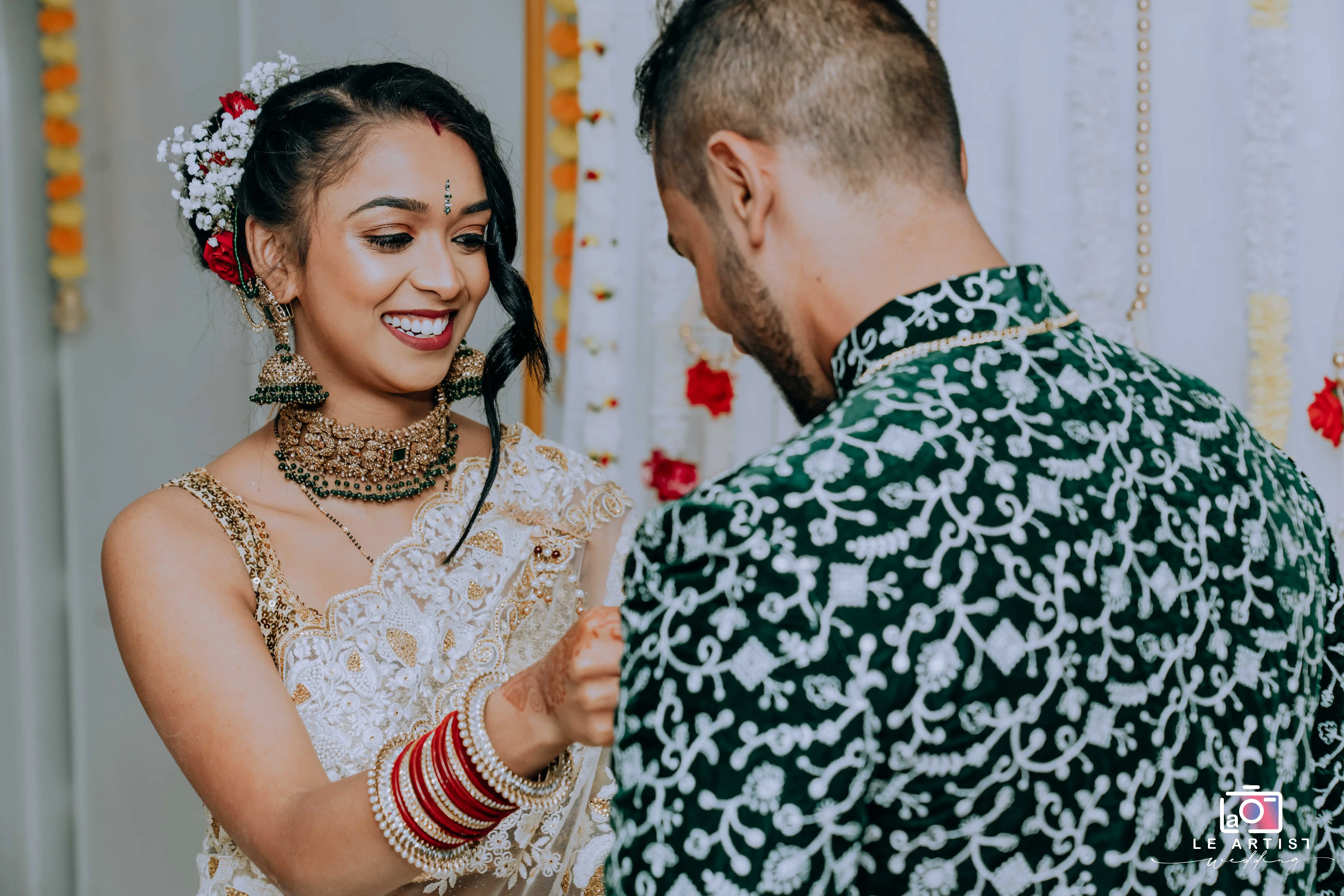 A joyful moment during the wedding ceremony as the couple exchanges heartfelt gestures and smiles. Le Artist Wedding