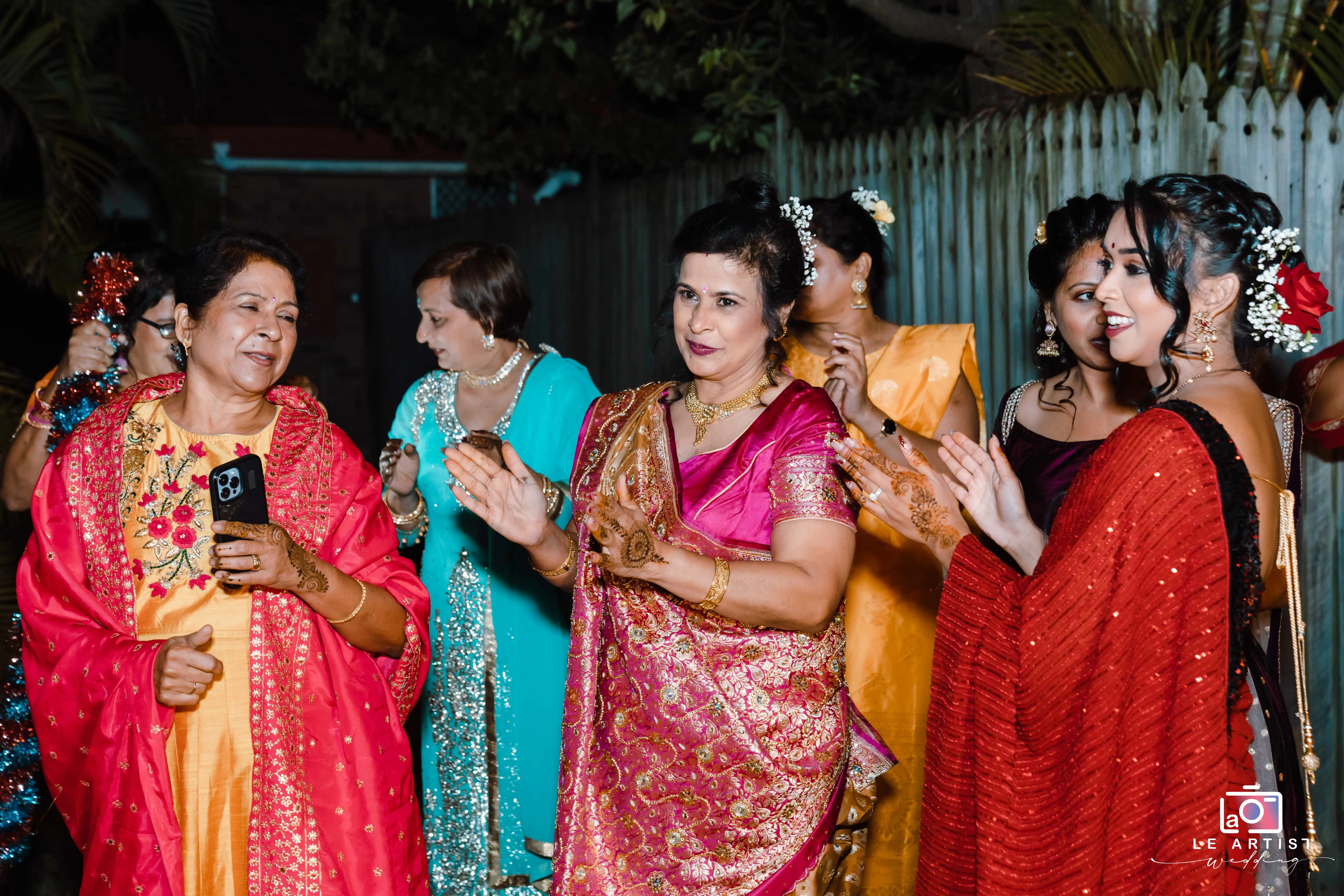 Guests dance and enjoy the festivities during the wedding reception, dressed in vibrant traditional attire. Le Artist Wedding