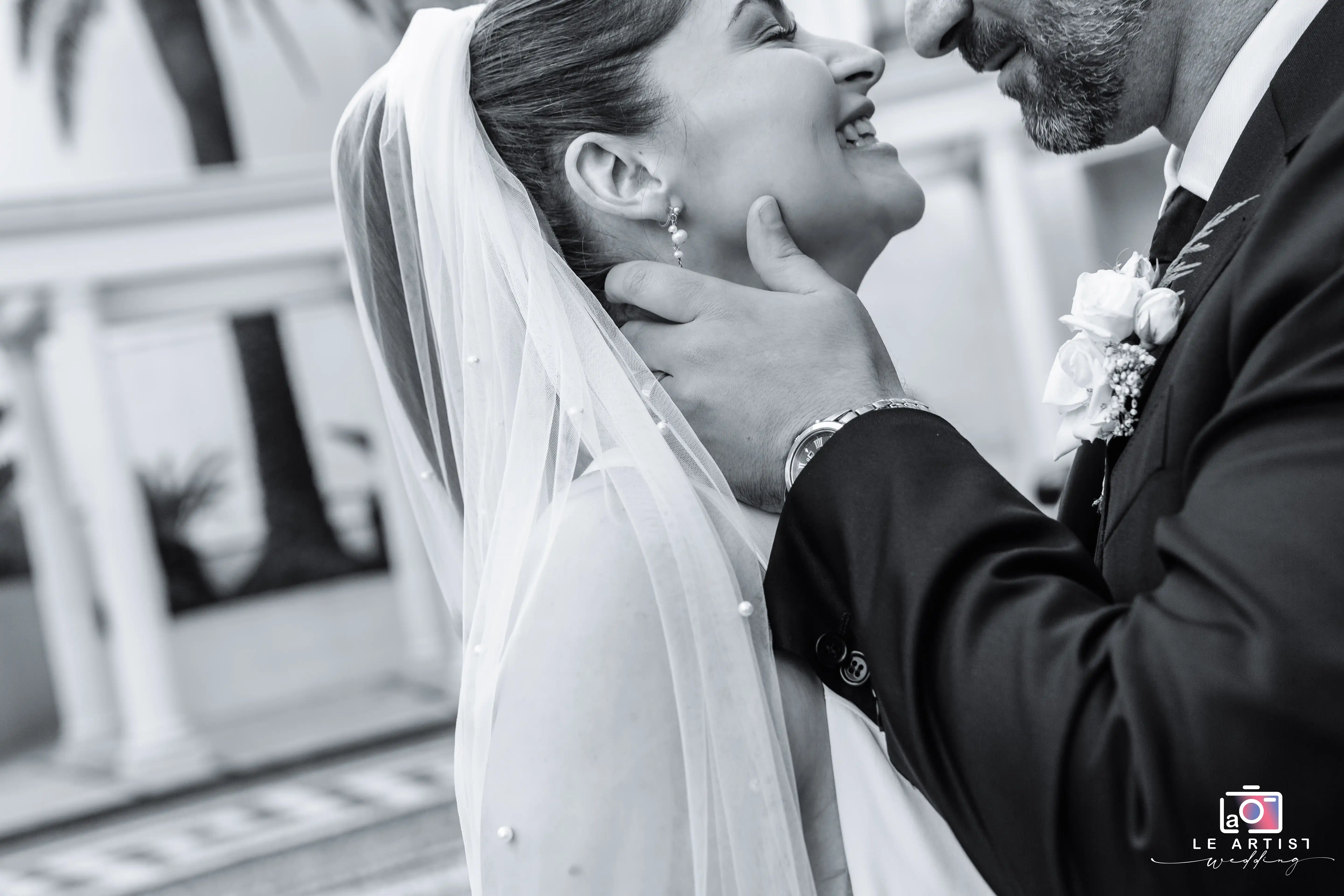 A tender black and white moment captured between the bride and groom during their photoshoot, highlighting their joy and connection. Le Artist Wedding