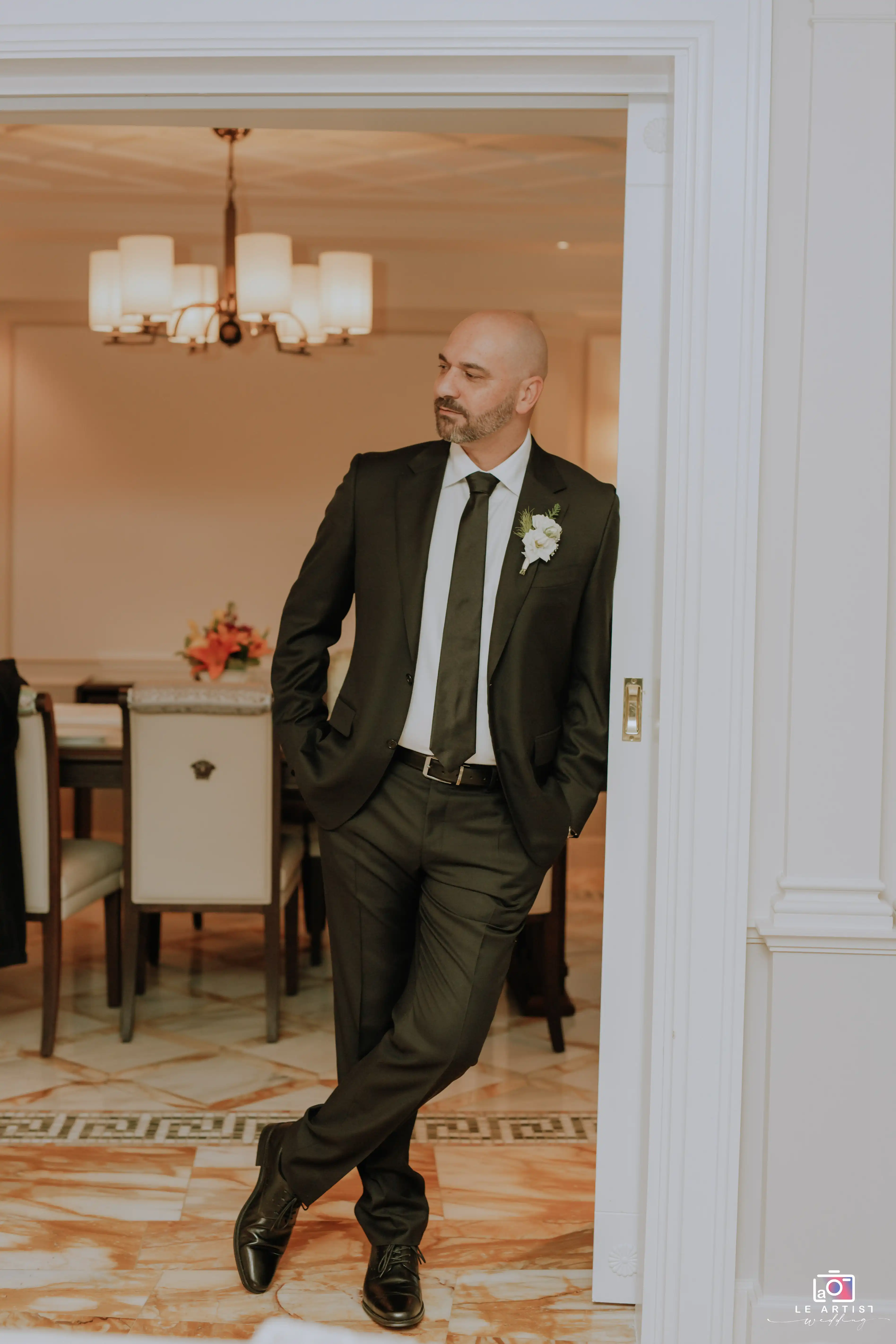 The groom stands poised in a sharp suit, ready for the big day ahead. Le Artist Wedding