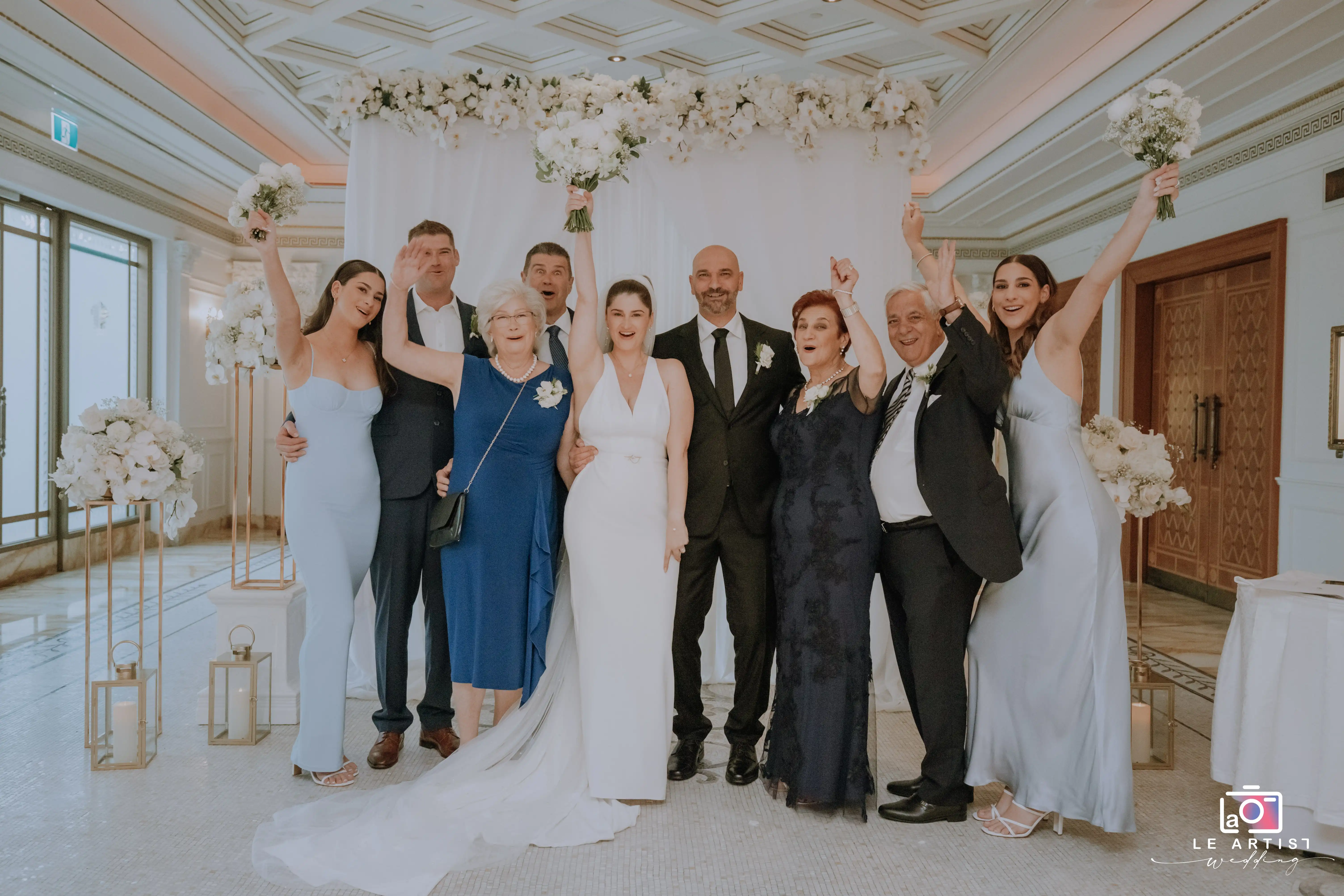 The newlyweds celebrate with their family and friends after the ceremony, surrounded by beautiful floral arrangements. Le Artist Wedding