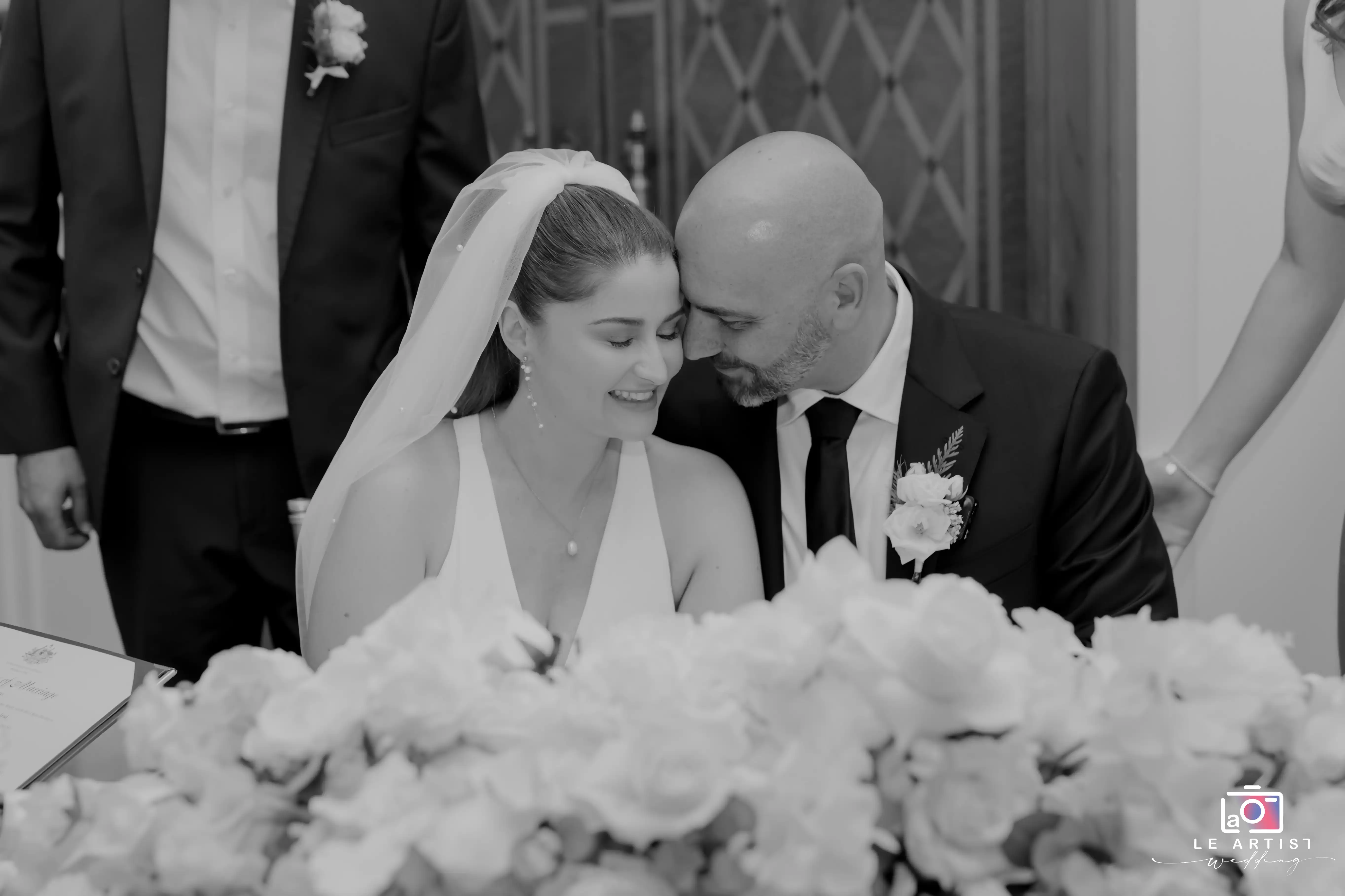 The bride and groom share a tender moment after signing the marriage certificate, marking the beginning of their new life together. Le Artist Wedding