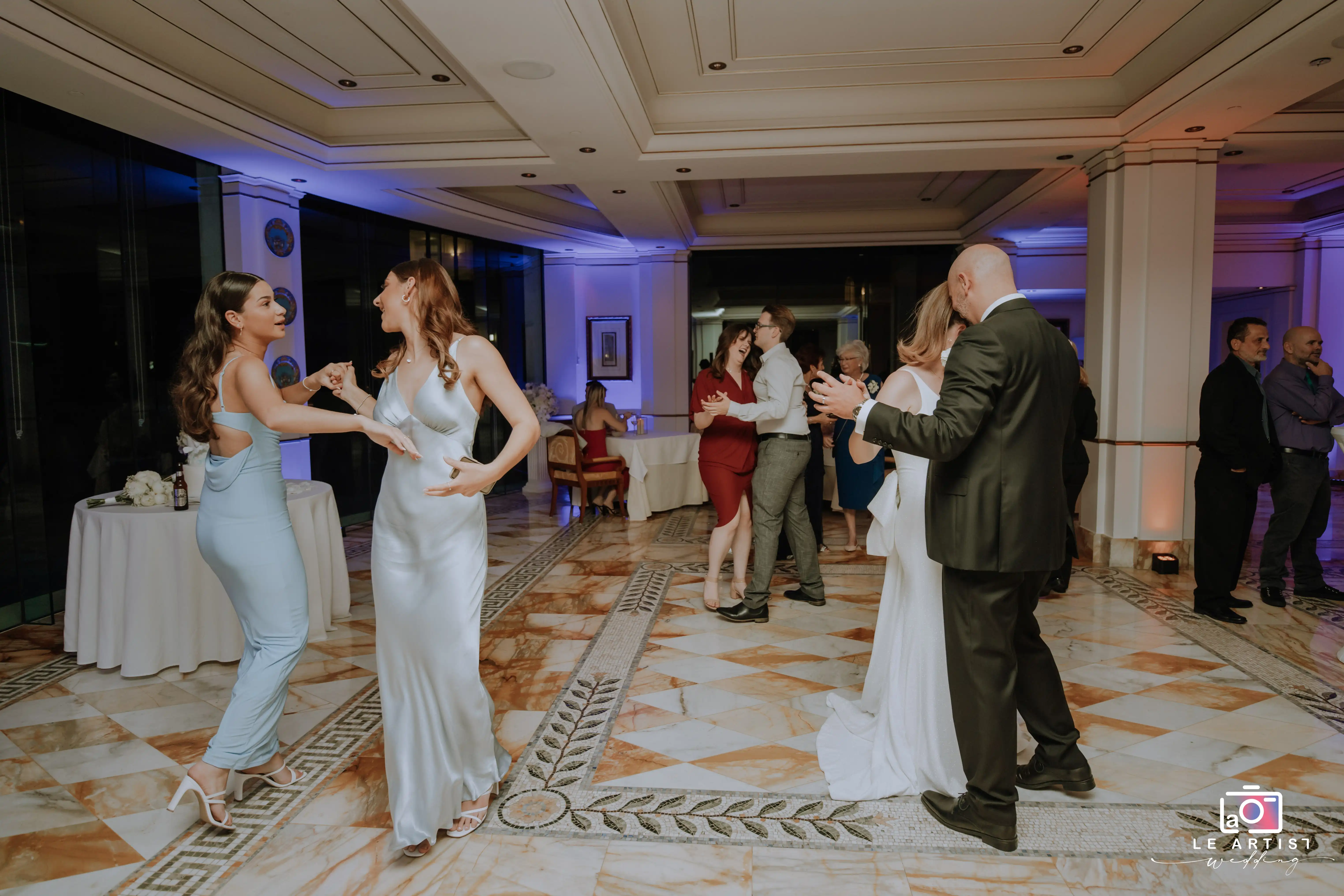 Guests enjoy dancing and celebrating during the wedding reception, creating lively and joyful moments on the dance floor. Le Artist Wedding