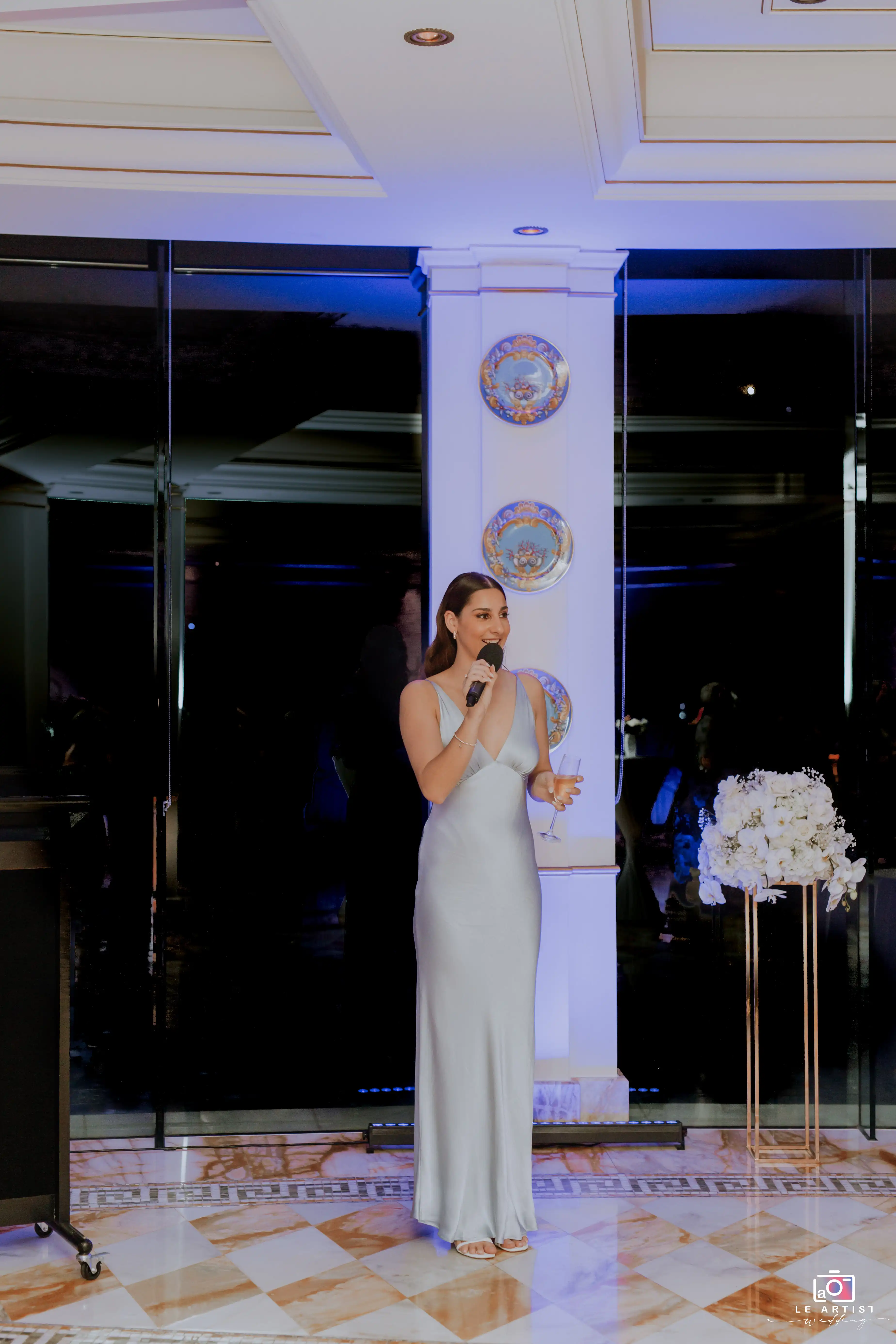 A guest shares a heartfelt speech during the wedding reception, creating a joyful and celebratory atmosphere. Le Artist Wedding