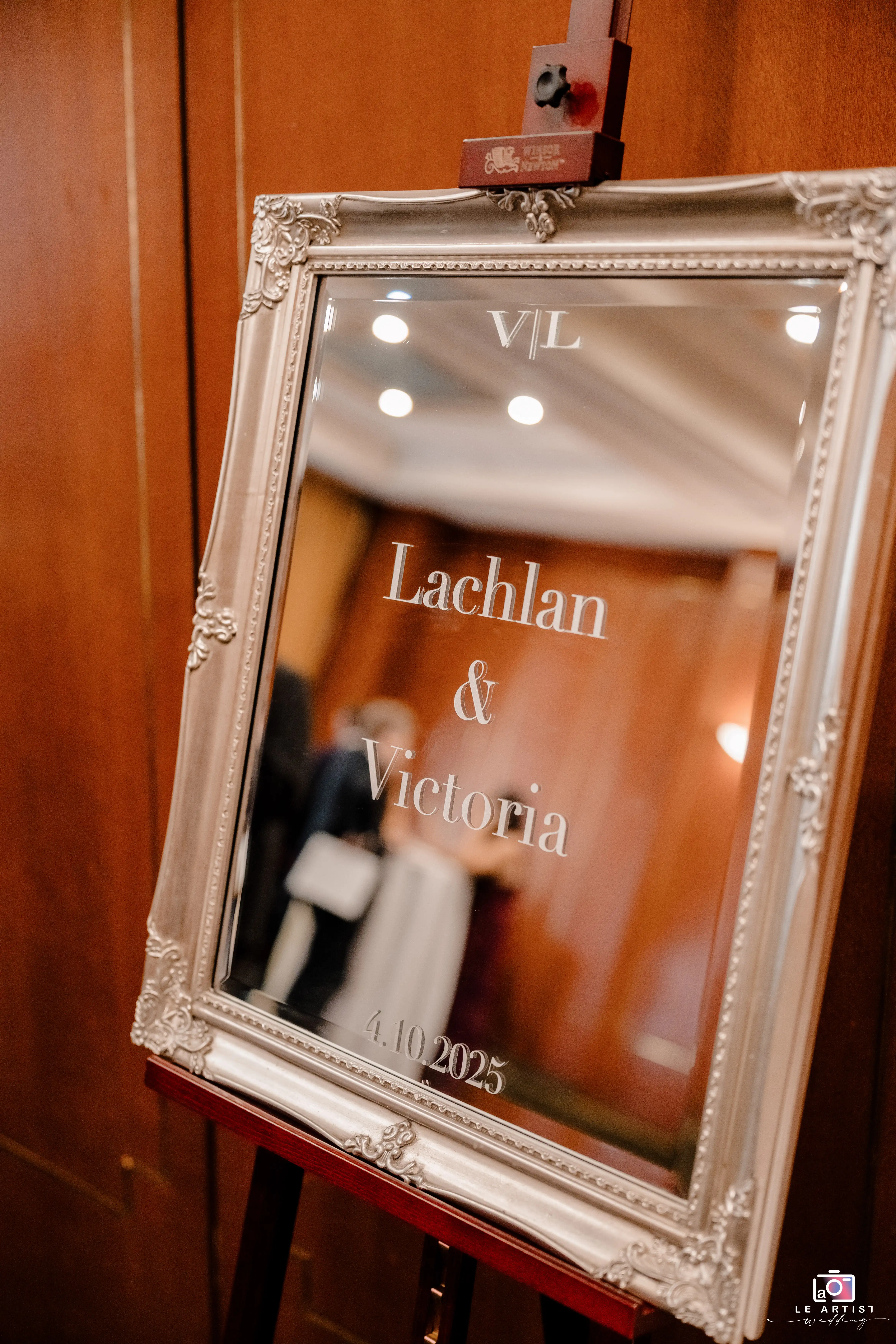 An elegant mirror sign welcomes guests to the wedding of Lachlan and Victoria, adding a touch of sophistication to the event entrance. Le Artist Wedding