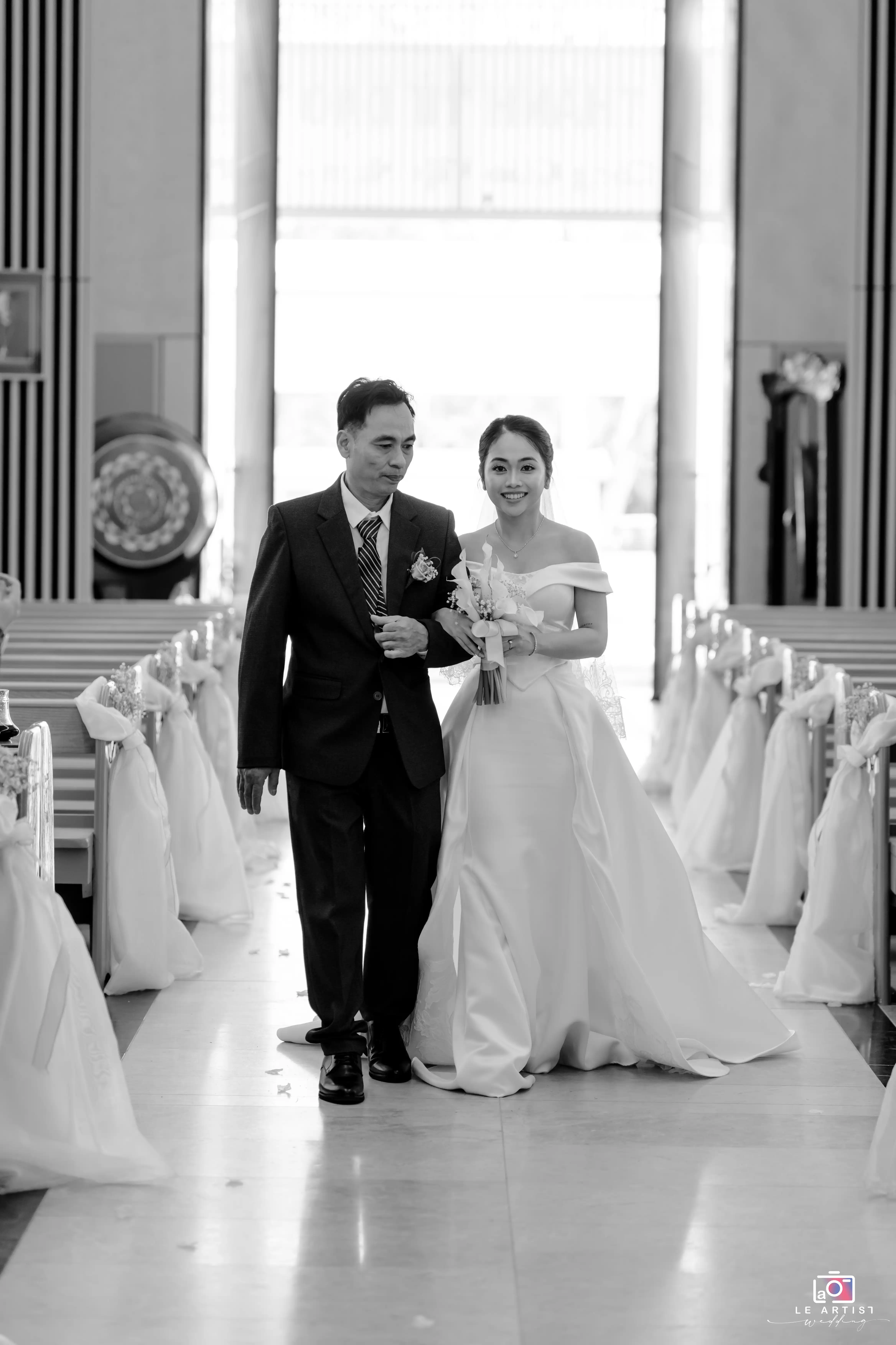 A touching moment as the bride walks down the aisle, accompanied by a loved one, capturing a beautiful beginning to the ceremony. Le Artist Wedding
