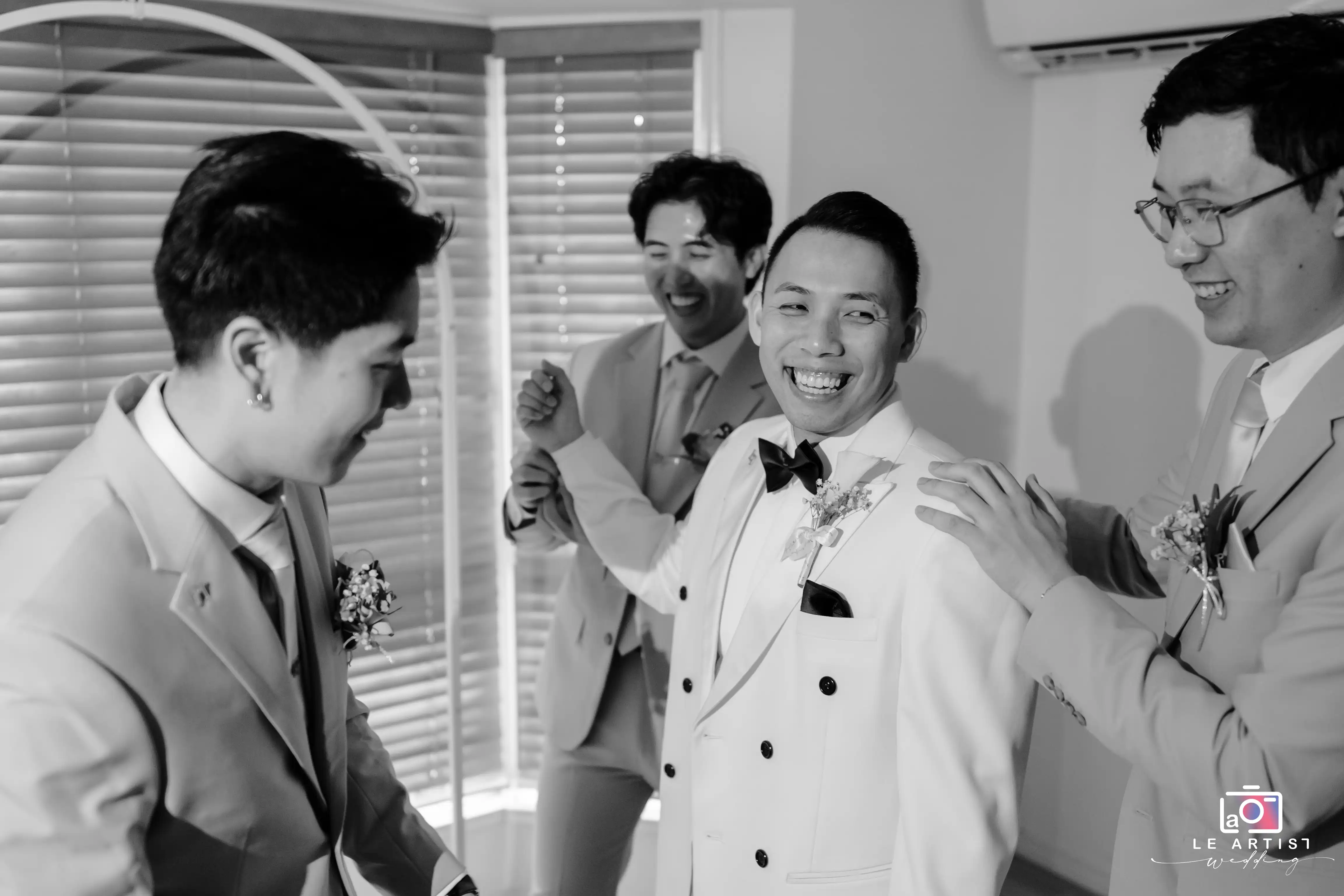 A joyful moment shared among the groom and his groomsmen, capturing laughter and camaraderie before the ceremony. Le Artist Wedding