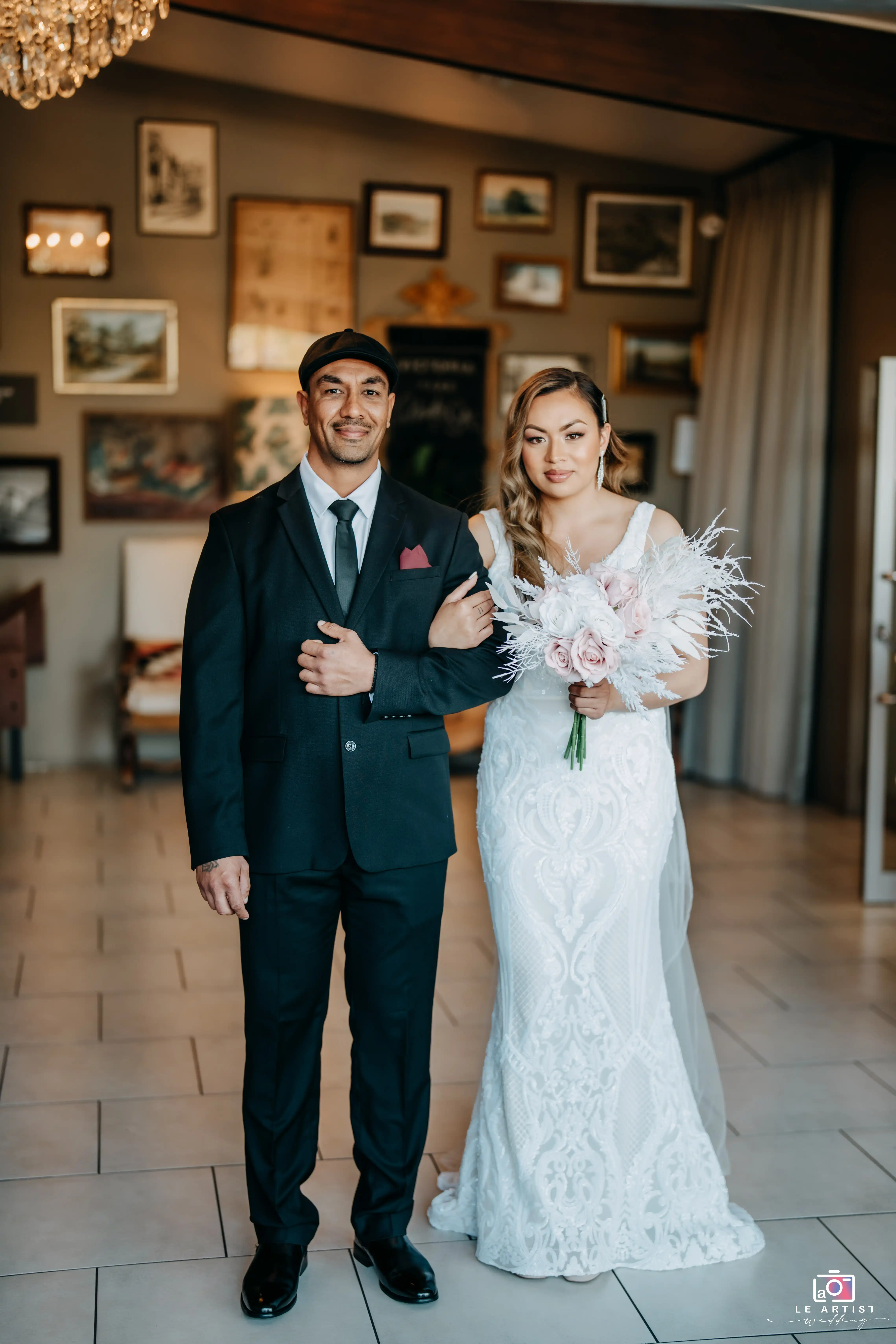 The bride prepares to walk down the aisle, escorted by a loved one, showcasing a moment filled with anticipation and emotion. Le Artist Wedding