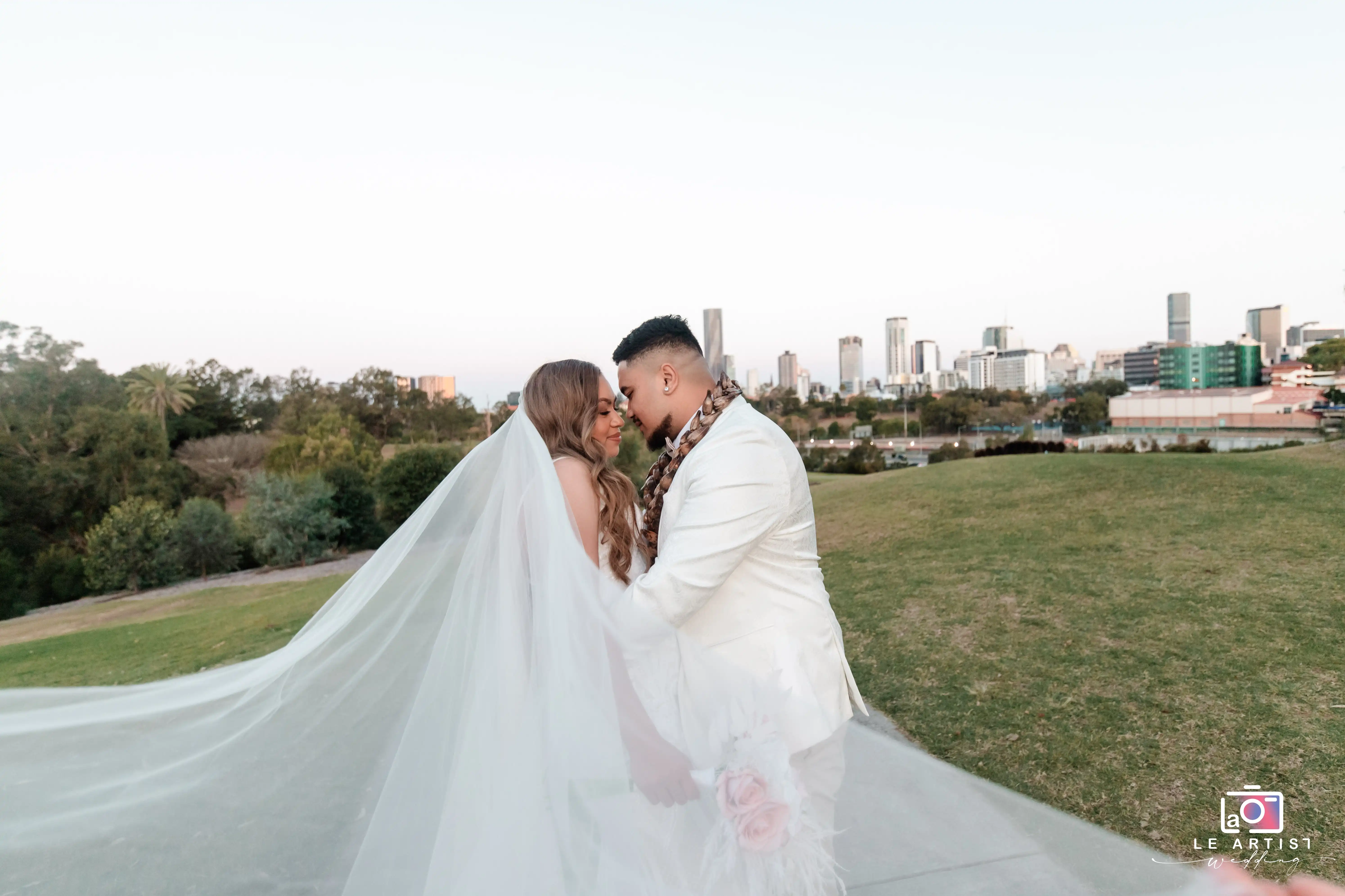 The couple shares an intimate moment during their photoshoot with the city skyline in the background. Le Artist Wedding