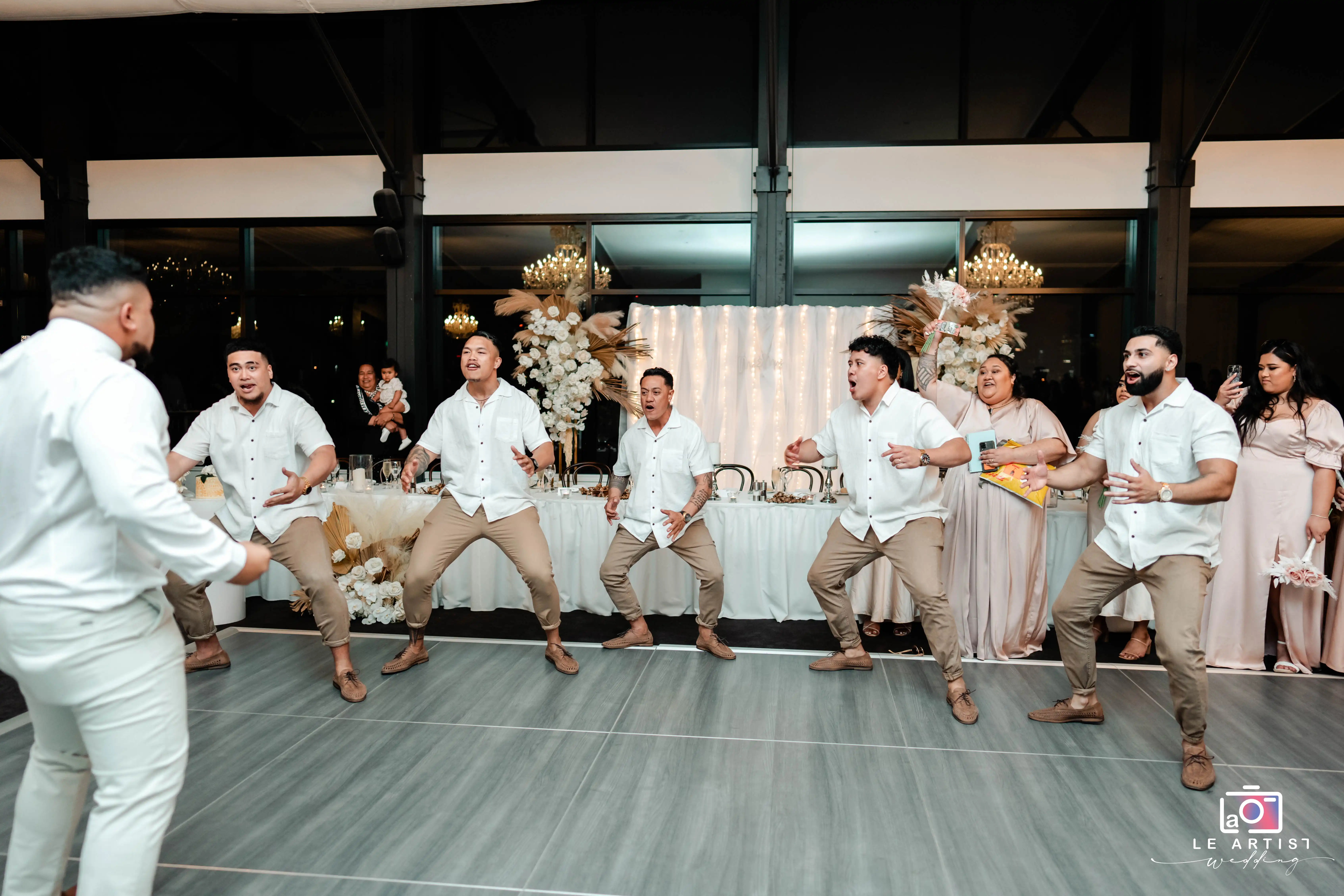Groomsmen perform a lively dance routine during the wedding reception, entertaining the guests with their coordinated moves. Le Artist Wedding