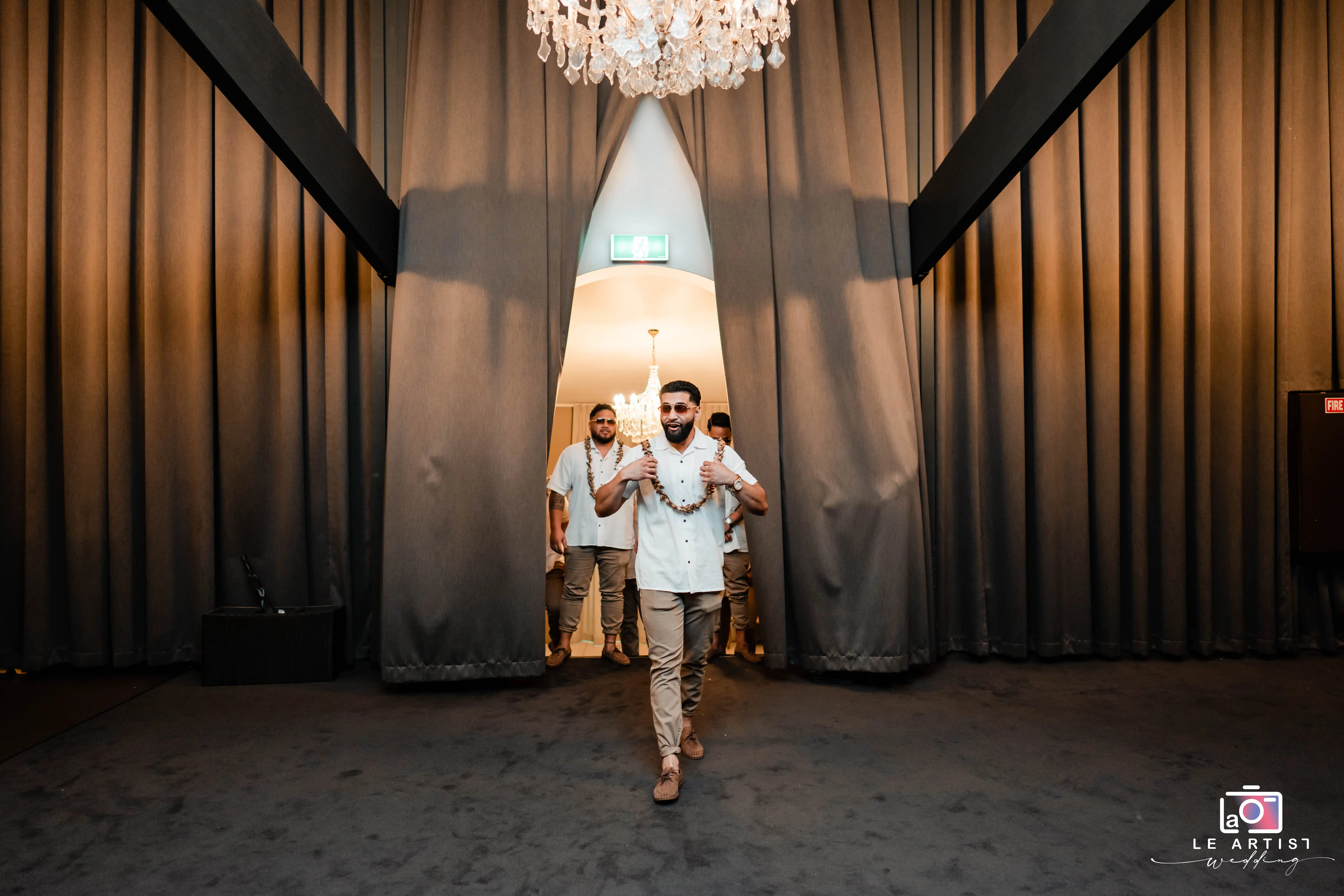The groomsmen make a lively entrance into the reception hall, setting an energetic tone for the celebration. Le Artist Wedding