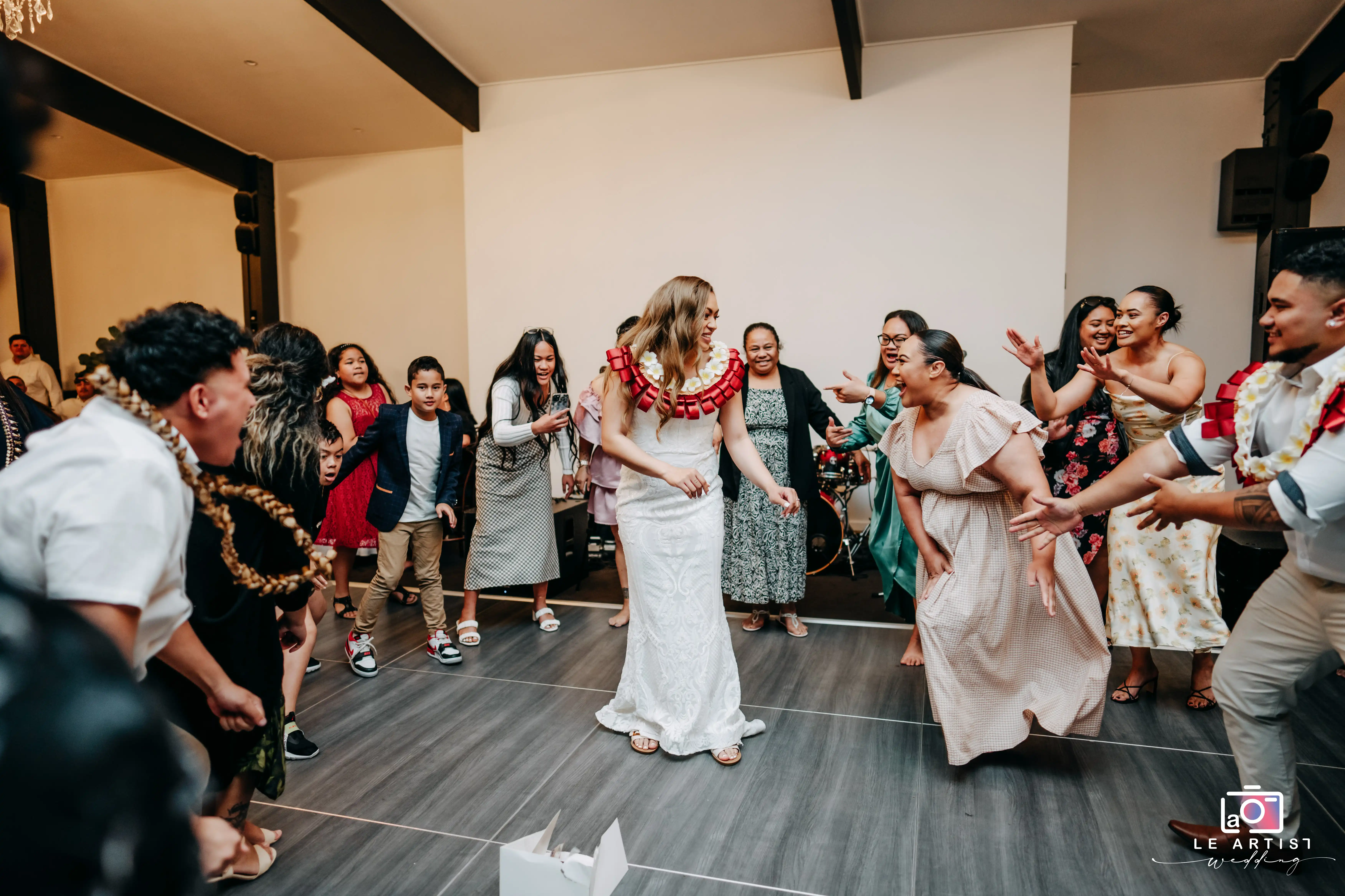 Guests join the bride on the dance floor, celebrating with joyful energy during the reception. Le Artist Wedding