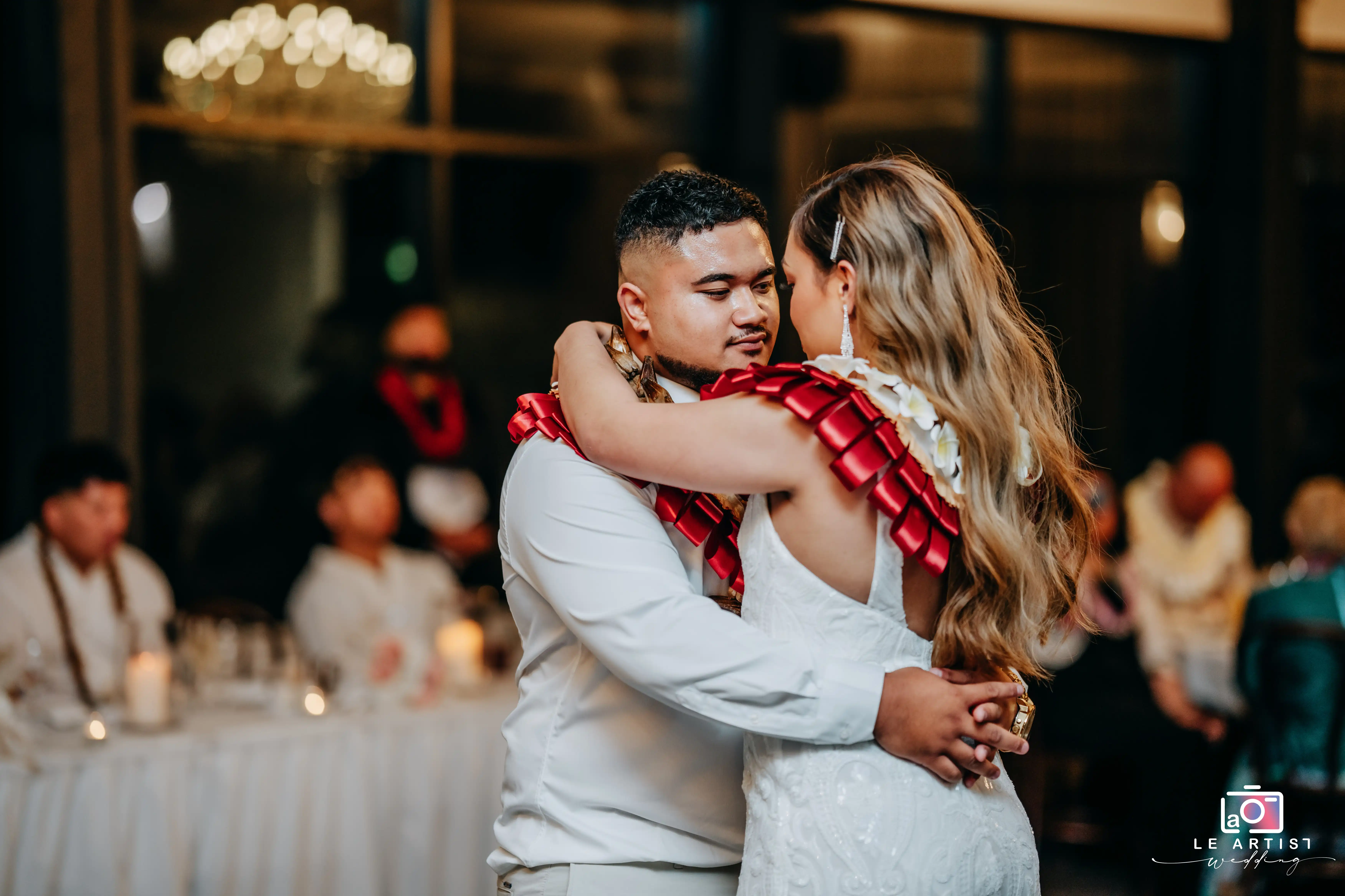 The couple shares a heartfelt dance adorned with leis. Le Artist Wedding