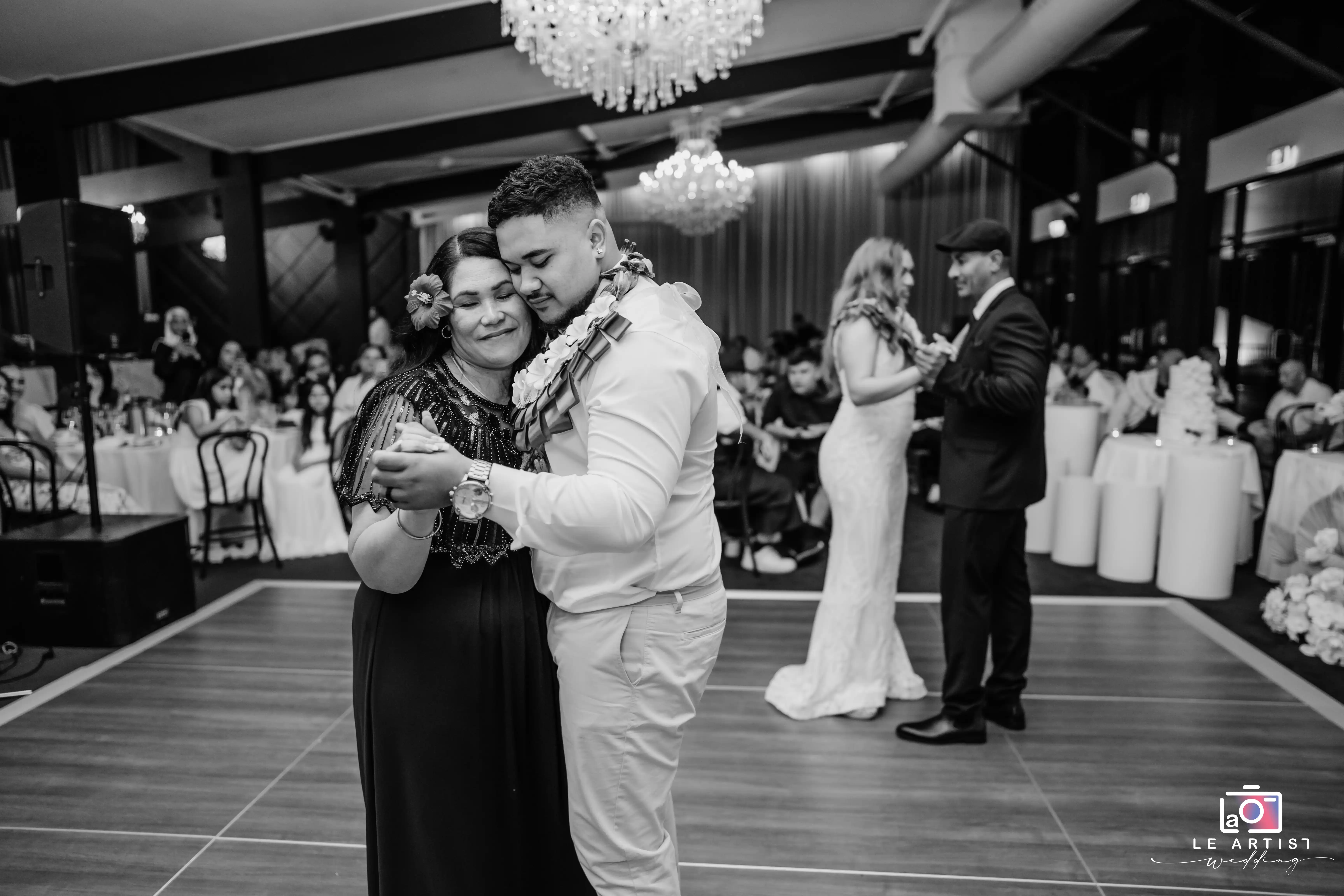 A joyful moment on the dance floor during the reception, with couples enjoying an intimate dance surrounded by guests. Le Artist Wedding