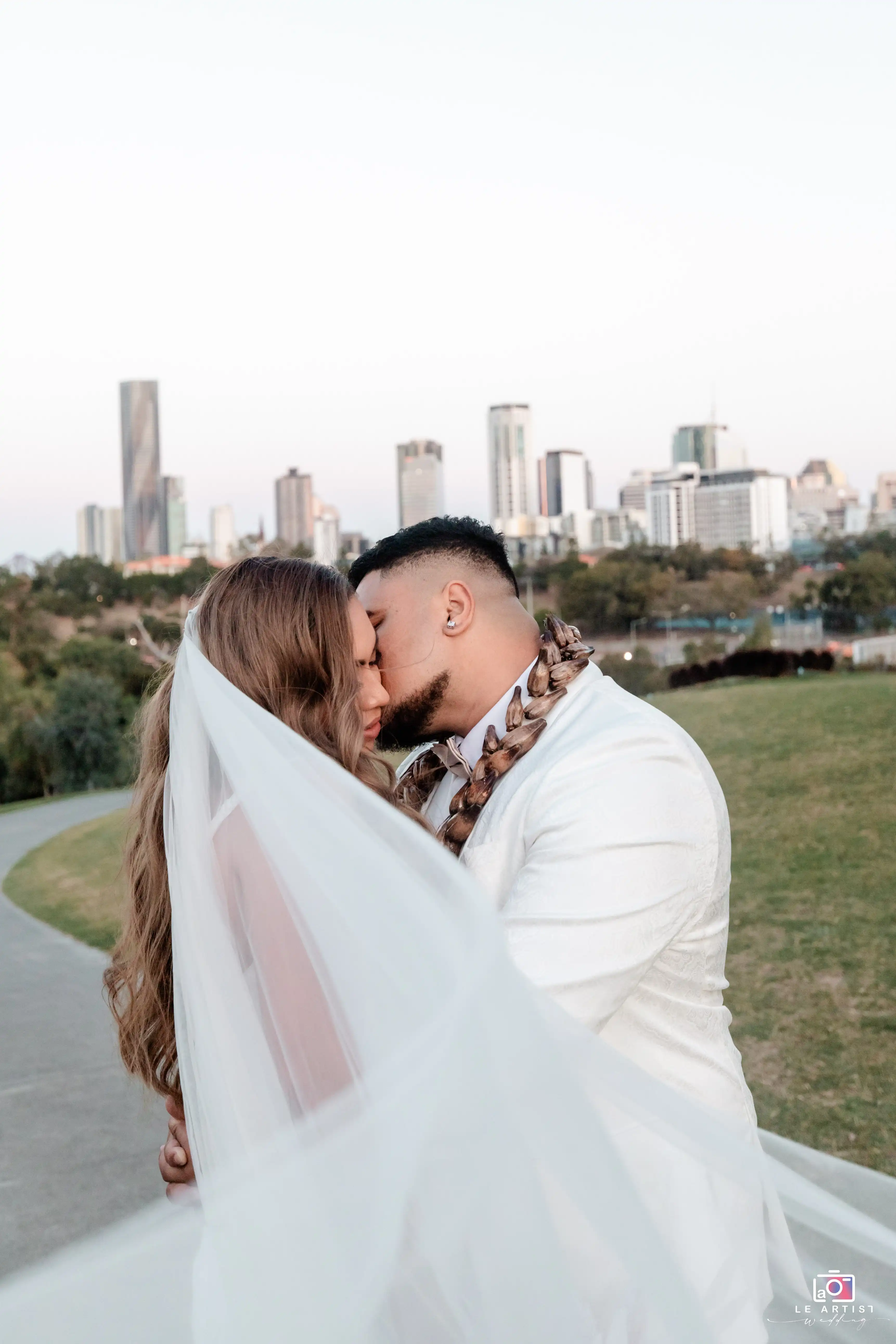 A romantic moment for the couple during their photoshoot with the city skyline in the background. Le Artist Wedding