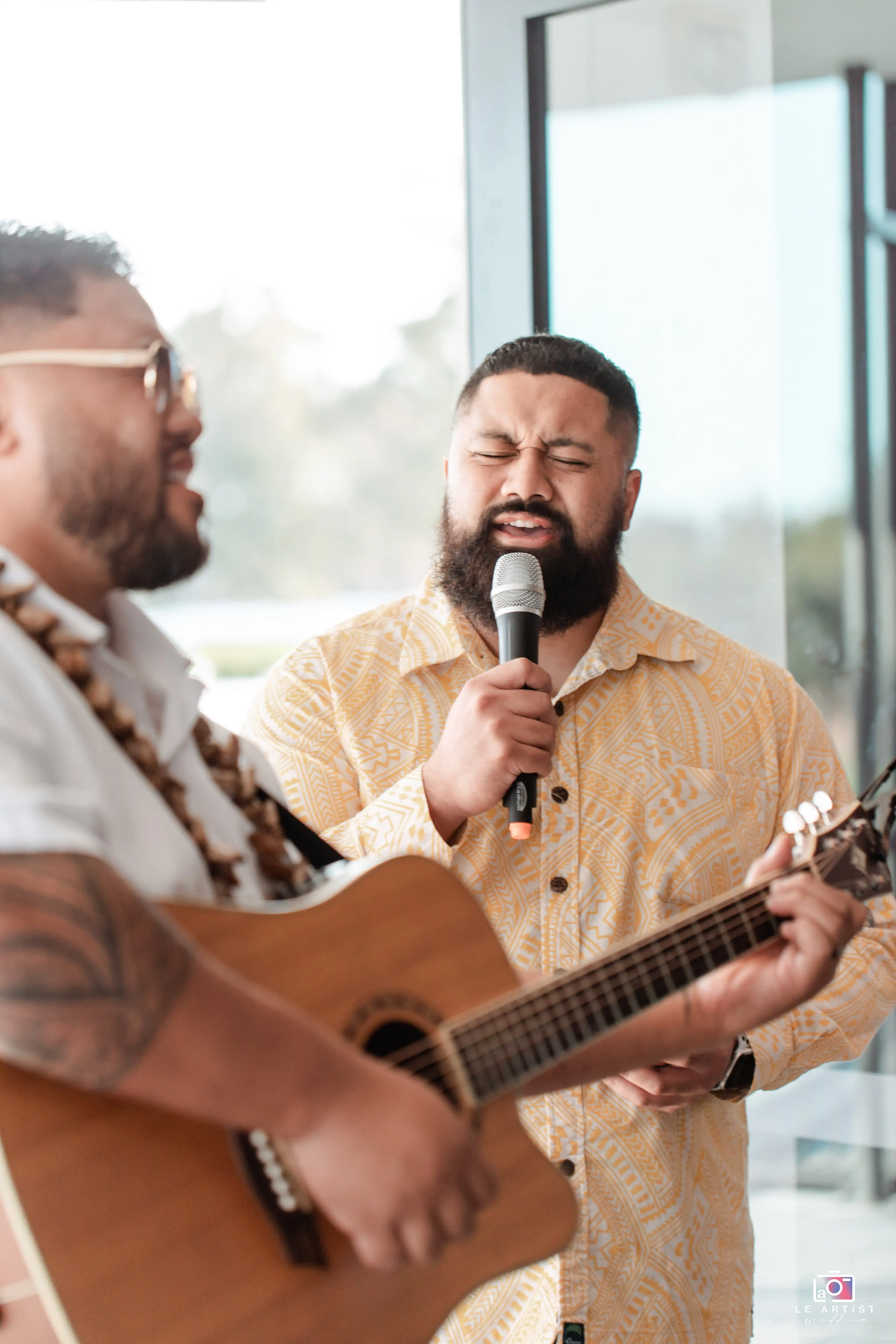 Performers singing and playing guitar, setting a lively atmosphere at the wedding reception. Le Artist Wedding
