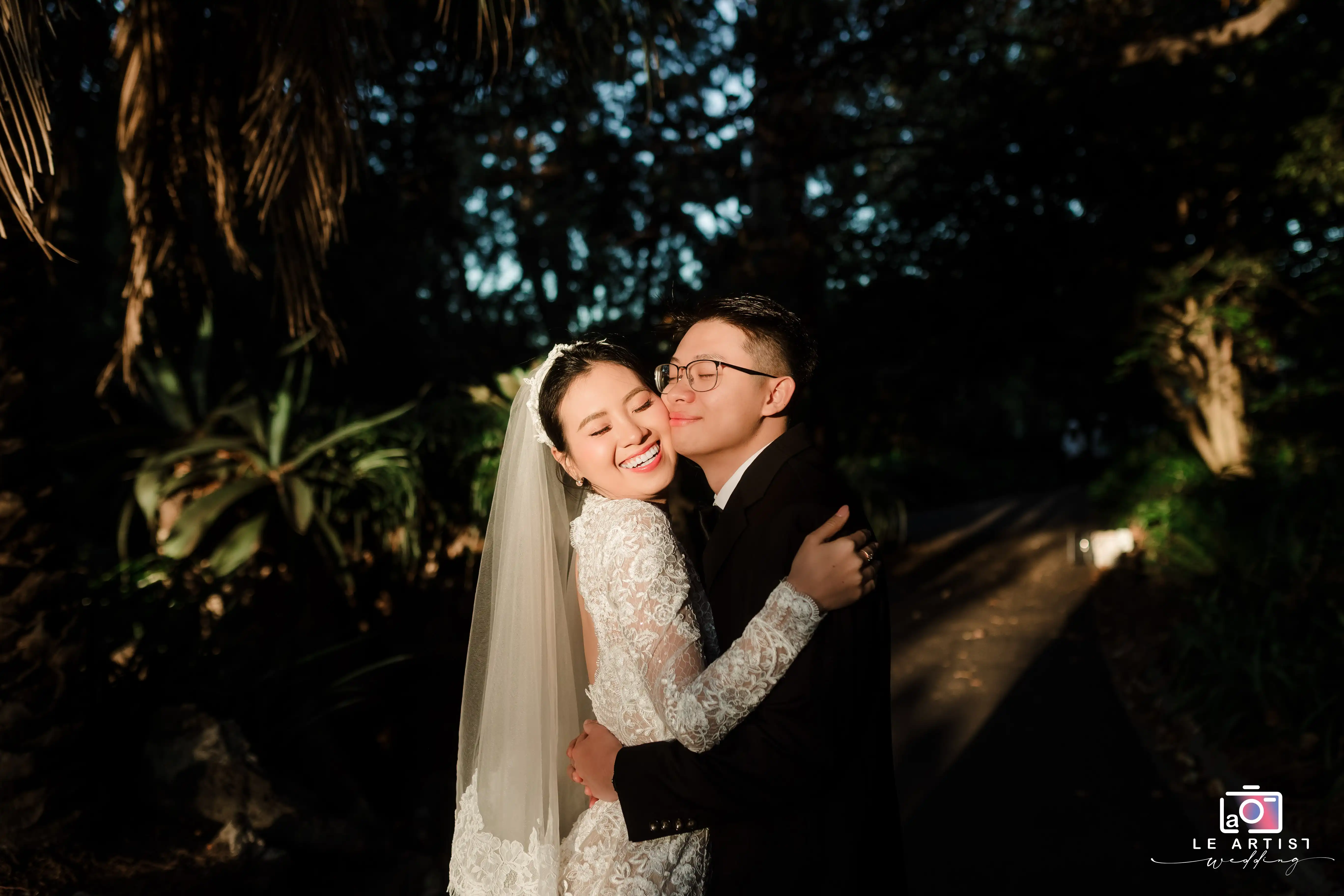 A joyful and romantic embrace captured in the golden light of dusk, showcasing the pure happiness and love shared between the newlyweds. Le Artist Wedding